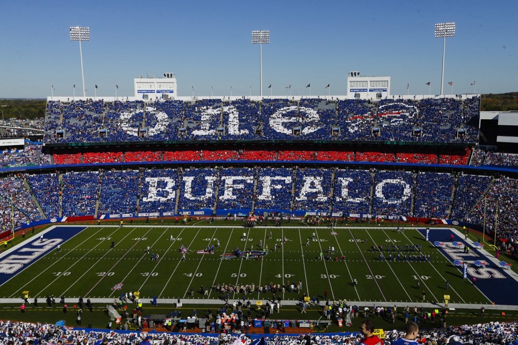Fans hold signs during a pre-game ceremony to announce new Buffalo Bills owners Terry and Kim Pegula before an NFL football game Sunday, Oct. 12, 2014, in Orchard Park, N.Y. (AP Photo/Frank Franklin II)
